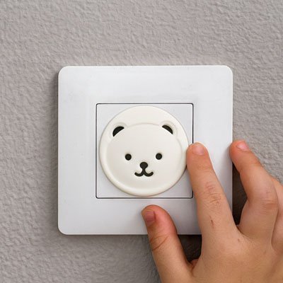 Cache prise en forme d’ours avec la mains de bébé