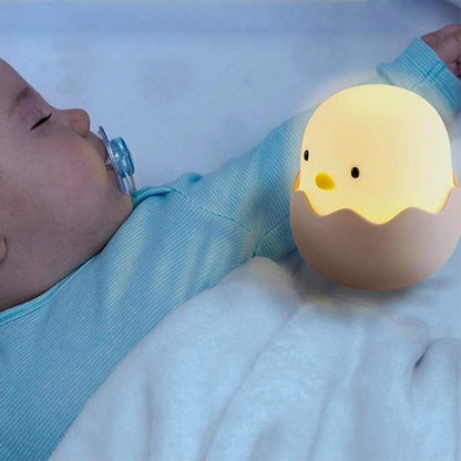 Veilleuse bébé poussin posée sur le lit